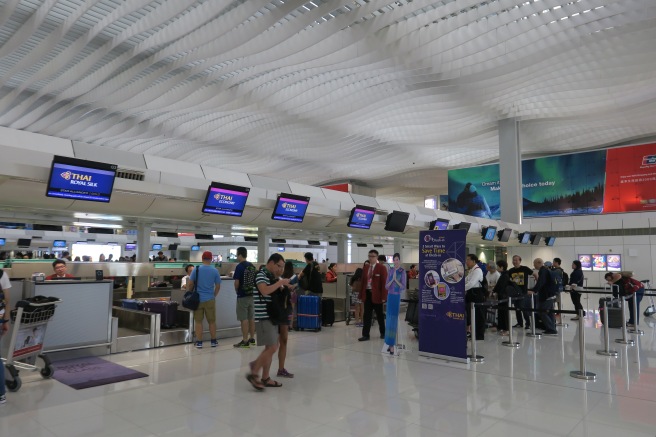 people in an airport with monitors