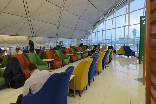 a group of people sitting in chairs in a room with large windows