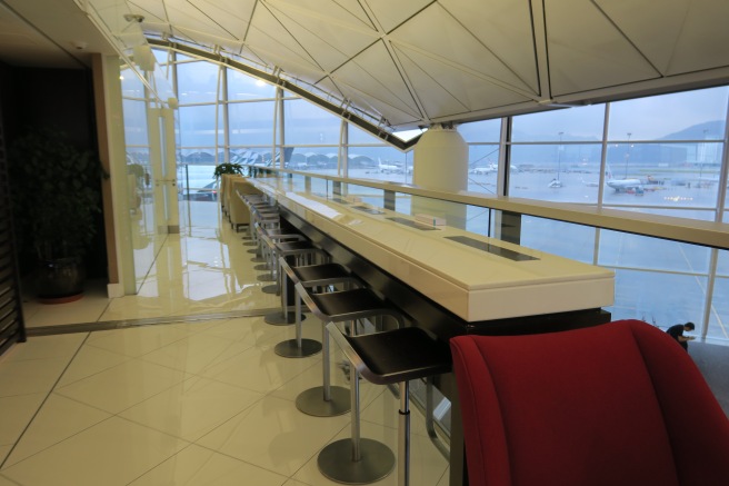 a long white bar with red chairs