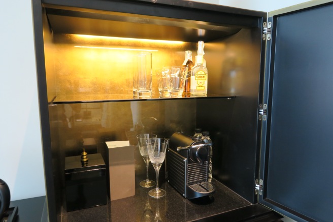 a shelf with glasses and a bottle of liquor