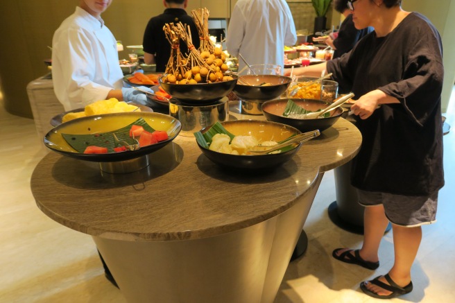 a group of people standing around a table full of food