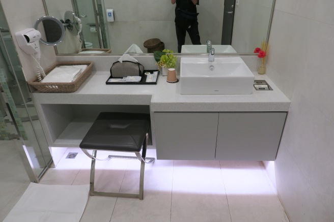 a bathroom sink with a mirror and a stool