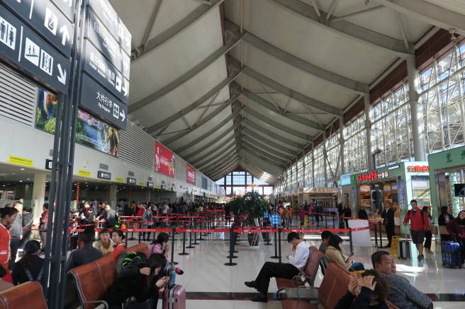 people in a terminal with people waiting for their flight