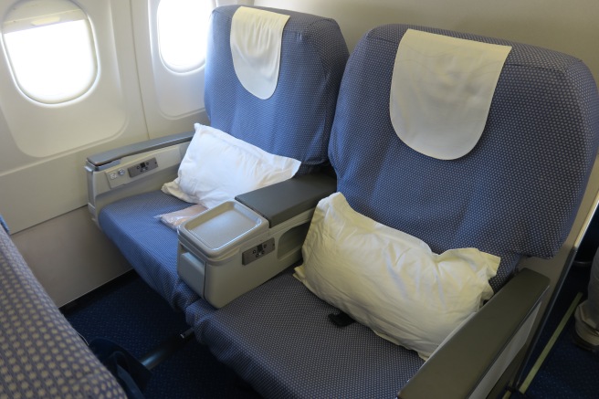 a seat with a white pillow and a white pillow on the side