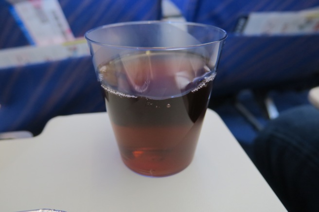 a glass of brown liquid on a white table