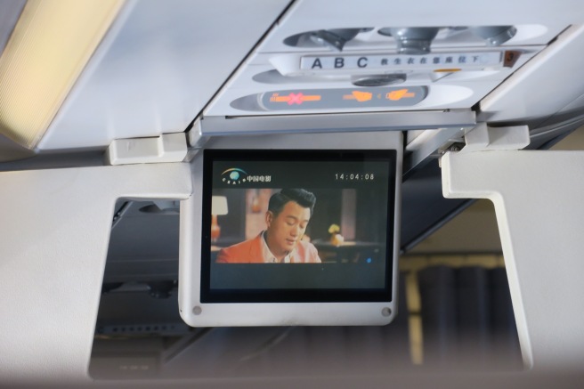 a screen on the ceiling of an airplane