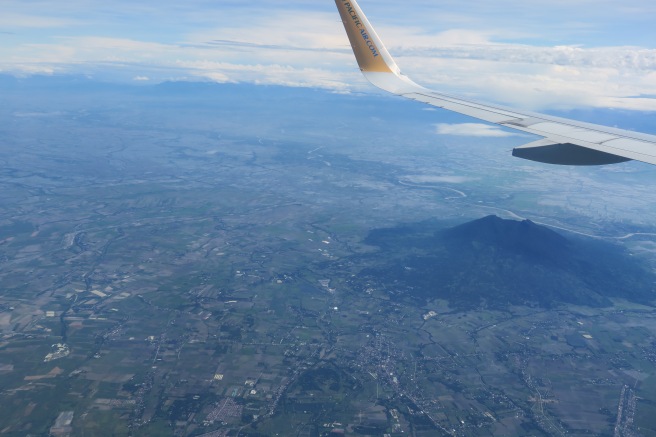 an airplane wing above a landscape