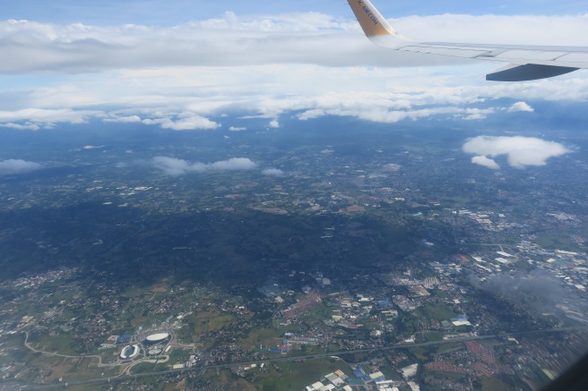 an airplane wing above a landscape