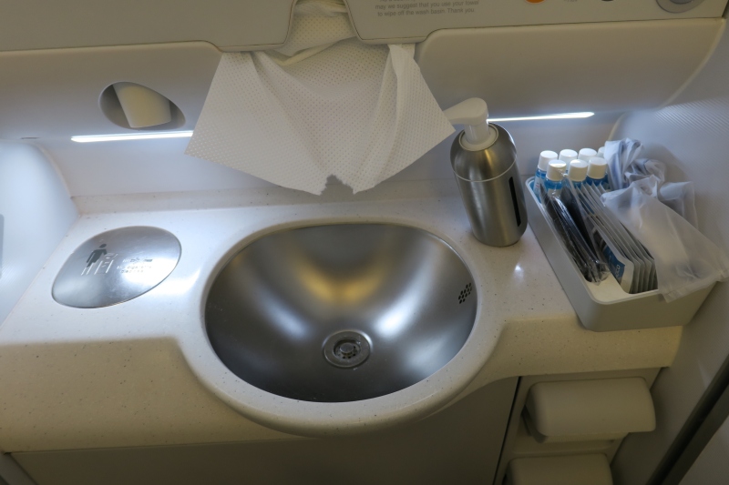 a sink with a silver container and a silver soap dispenser