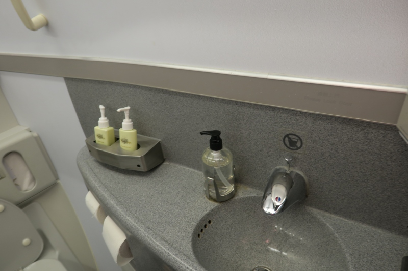 a sink with soap dispensers and a silver tray