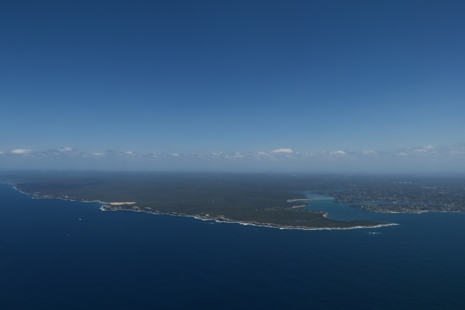 an aerial view of a body of water with land and buildings