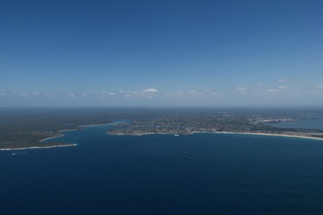 an aerial view of a body of water with land and buildings