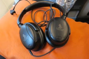 a pair of black headphones on an orange cushion