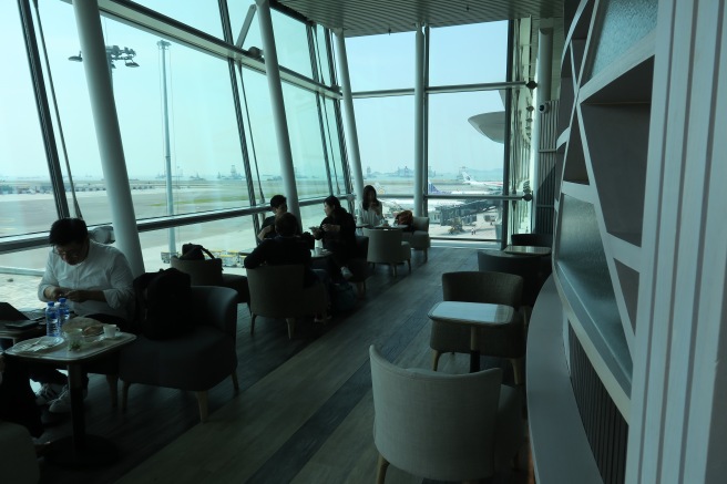 people sitting in a room with large windows