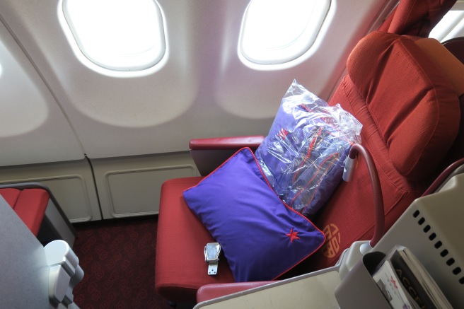 a seat with a pillow and a bag on it