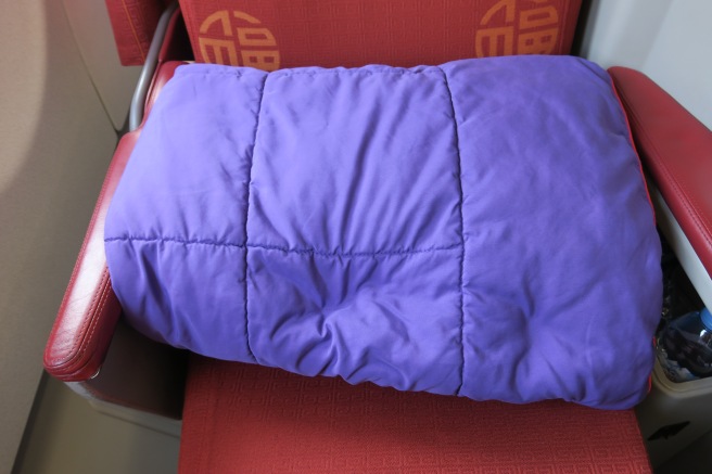 a purple blanket on a red seat