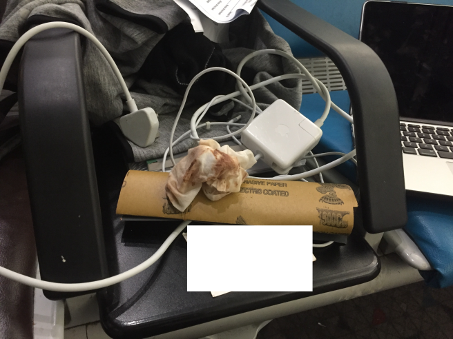 a white object with a paper roll and a white object on a black chair