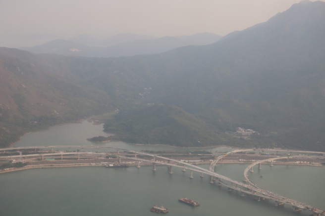 a bridge over water with mountains in the background