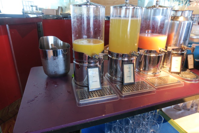 a group of juice dispensers on a table