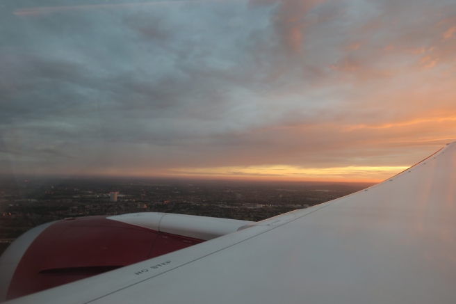 an airplane wing and a city in the distance