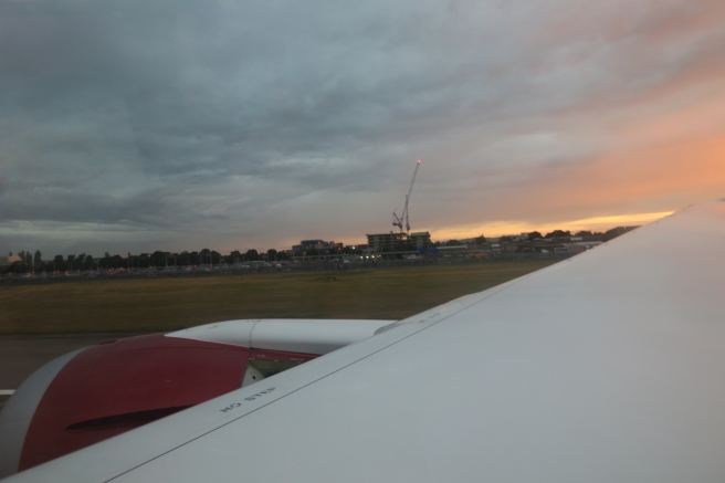 a plane wing with a crane in the background