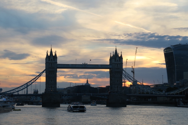 a bridge over water with a boat in the background