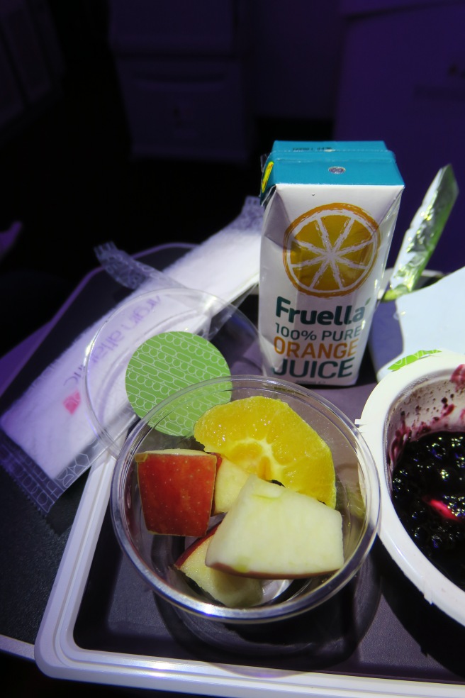 a bowl of fruit and juice on a table