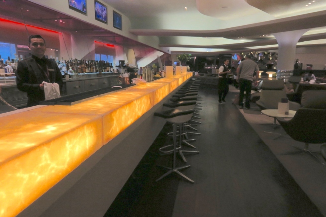 a bar with a long counter and chairs