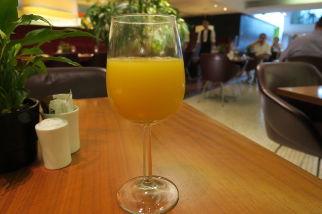 a glass of orange juice on a table