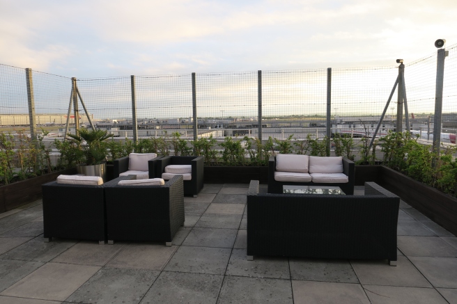 a patio with a fence and chairs