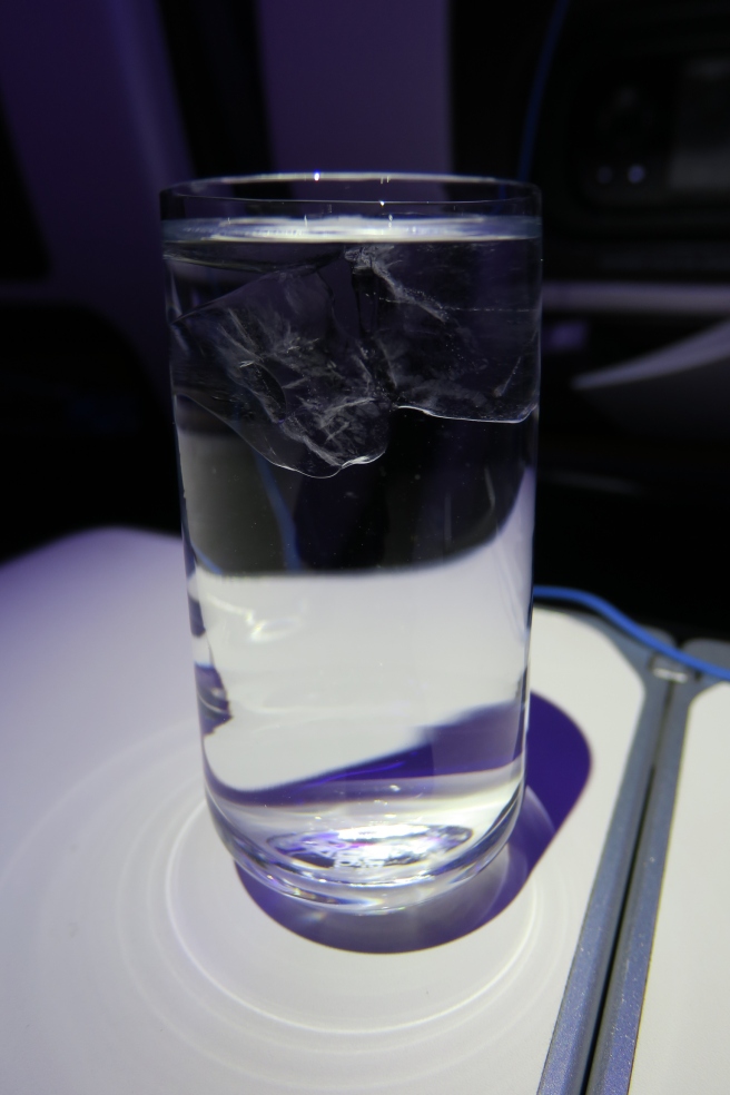 a glass of water with ice cubes in it