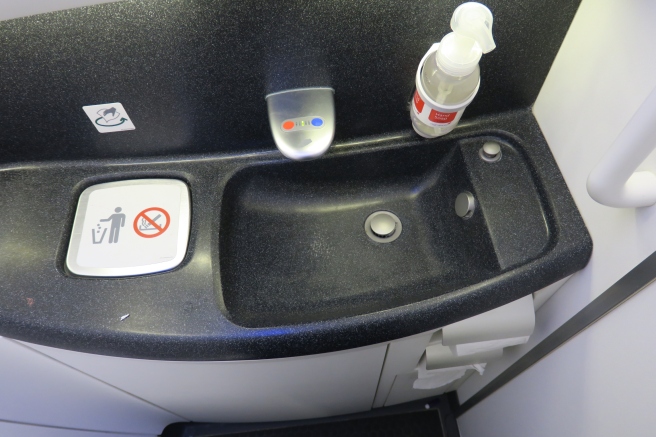 a sink with a bottle of liquid and a bottle of soap