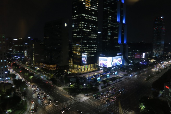 a city at night with cars and buildings