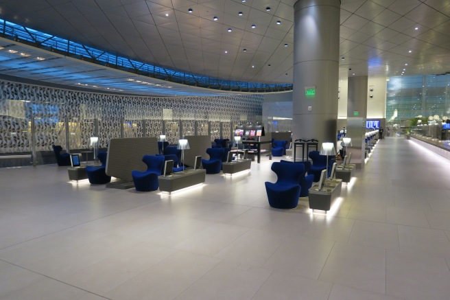 a large room with blue chairs and a large column