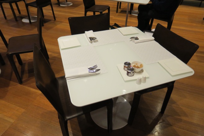 a table with a white tablecloth and black chairs