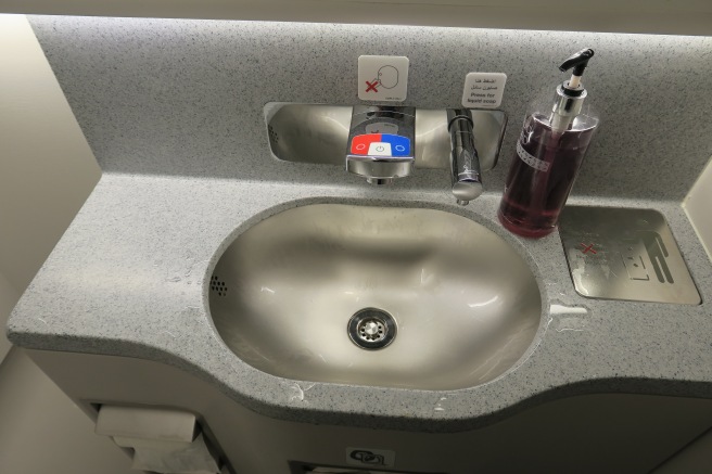 a sink with a soap dispenser and a bottle of liquid