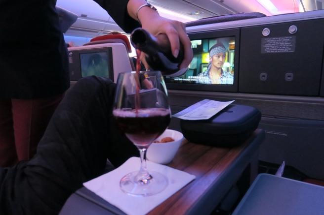 a person pouring wine into a glass on a table