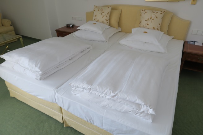 a bed with white sheets and pillows