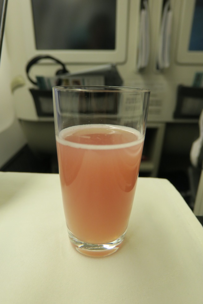 a glass of pink liquid on a table