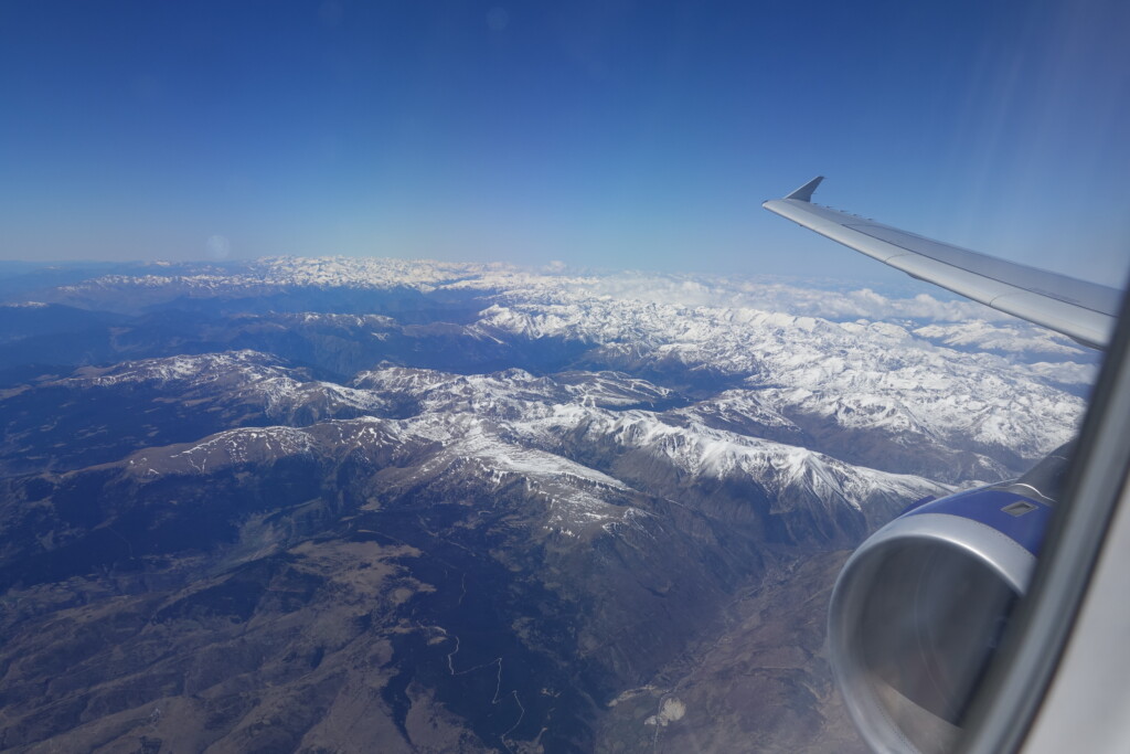 an airplane wing and snow covered mountains