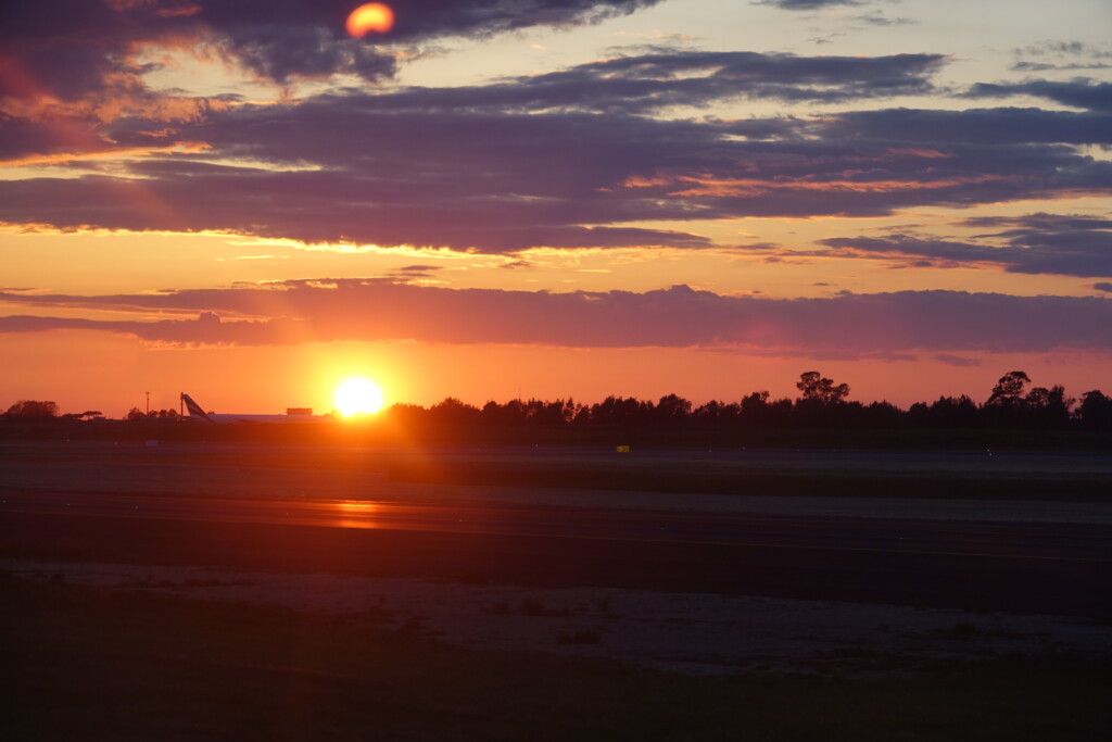 a sunset over a runway