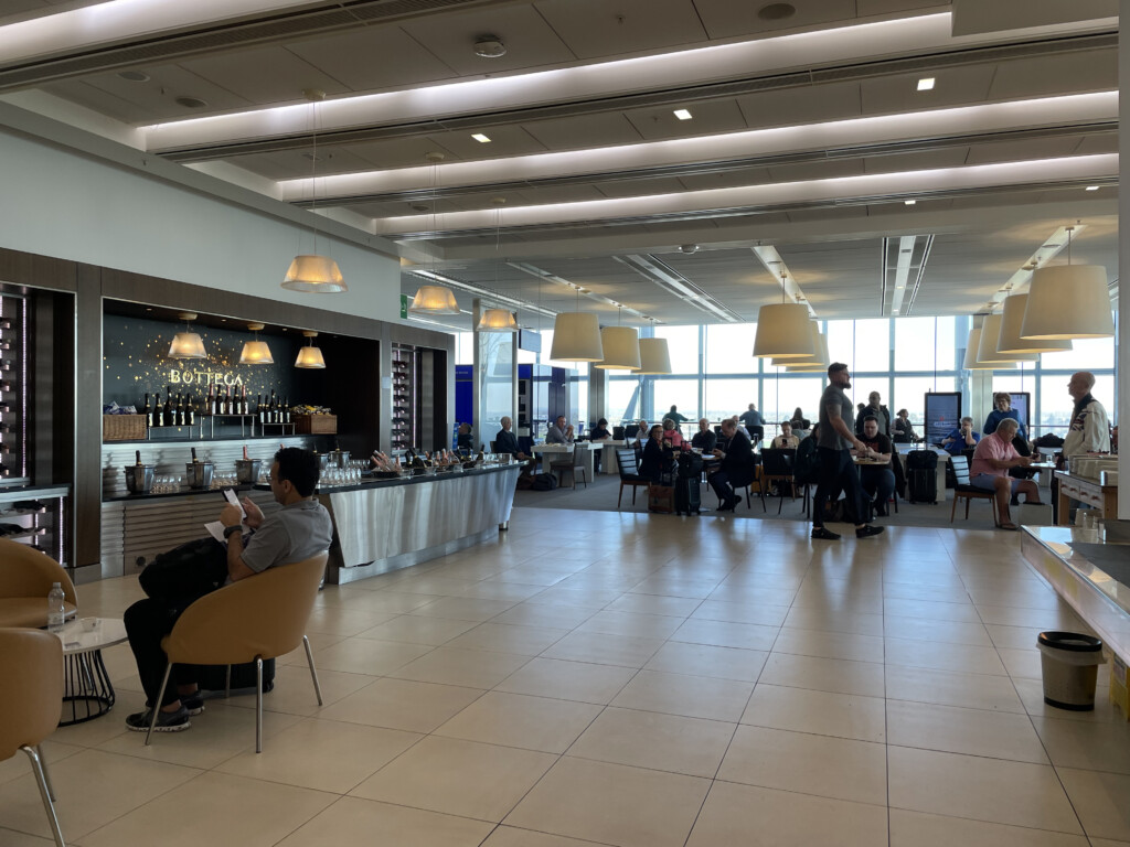 a large room with people sitting at tables and a bar