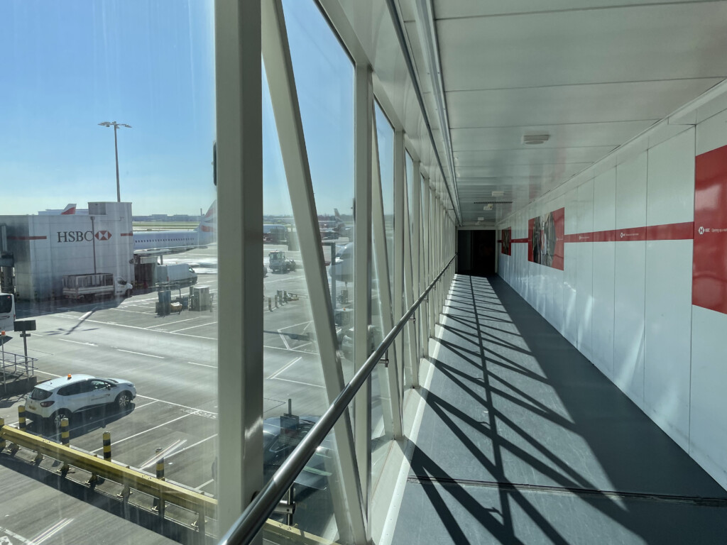 a long hallway with a railing and a parking lot