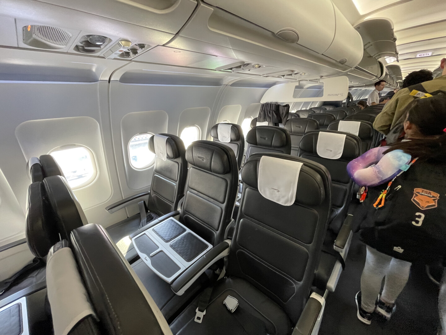 a person standing in a row of seats on an airplane