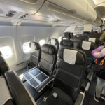 a person standing in a row of seats on an airplane