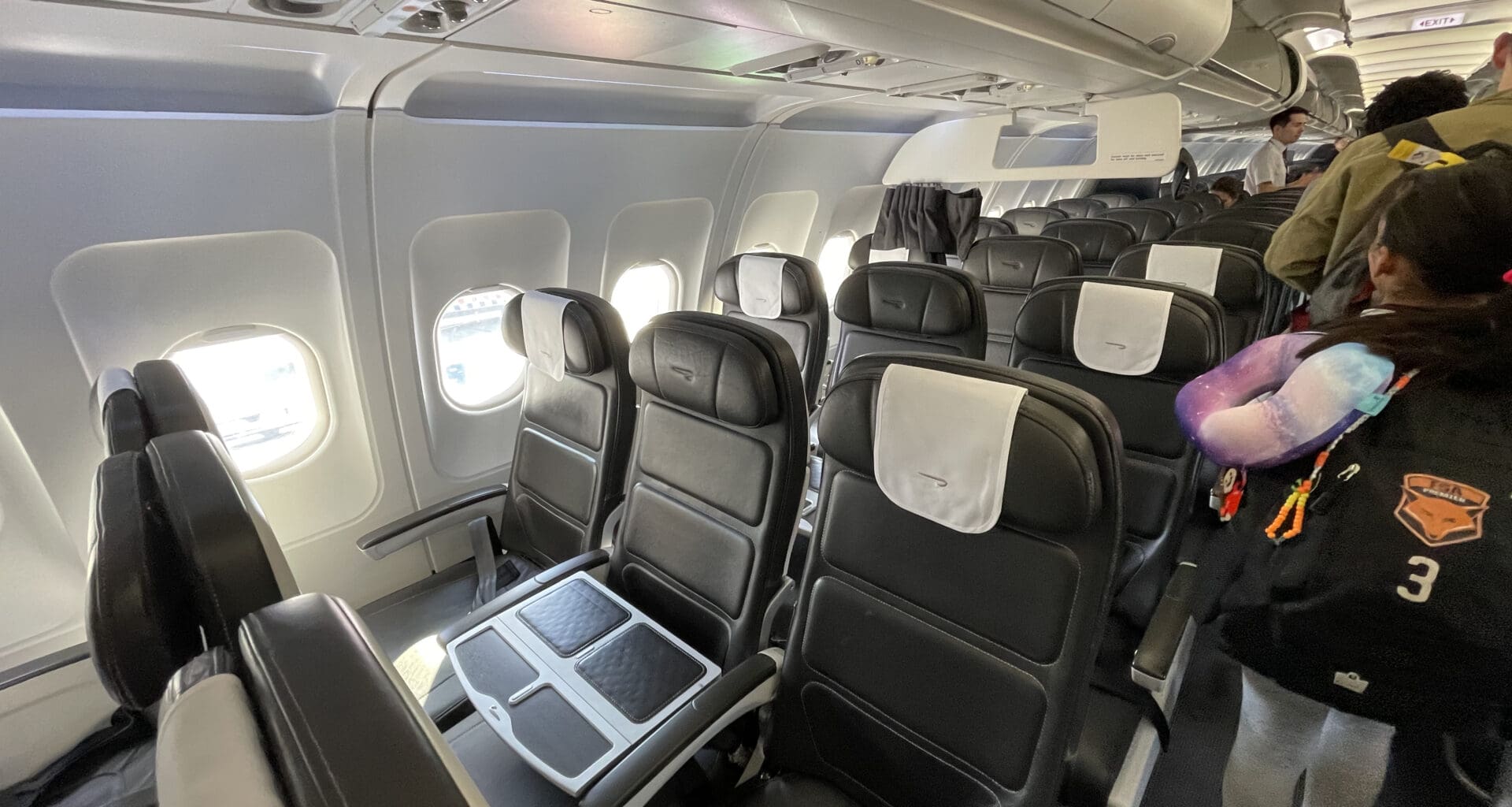a person standing in a row of seats on an airplane