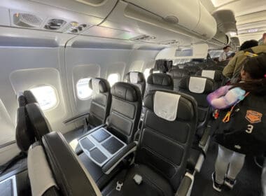 a person standing in a row of seats on an airplane