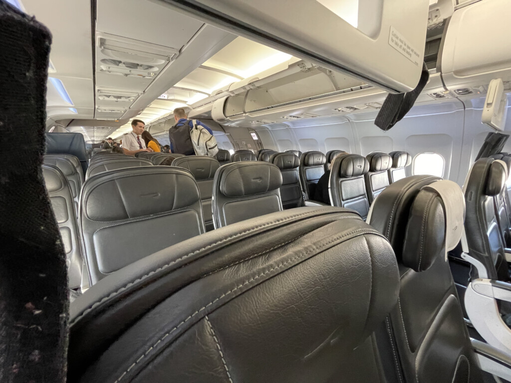 inside an airplane with seats and people in it