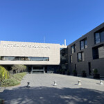 a building with a stone walkway and a sign