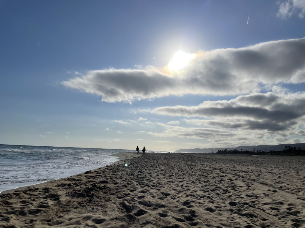 a beach with people walking on the beach